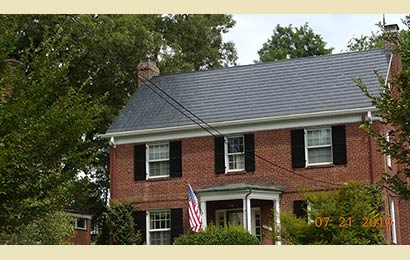 Red brick house with a roof of solar shingles.