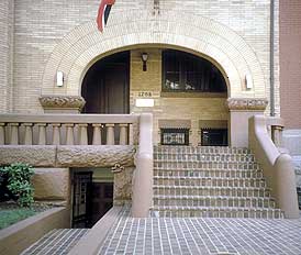 This is an image of a historic building with a distinctive arcade-like entry. It dominates the visual character because of its size, shape, location, materials, and craftsmanship. Photo: NPS files.