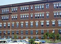 This is an image of a commercial buildings with distinctive multiple windows, grouped in different rhythms and accented by different colored arched heads. Photo: NPS files.