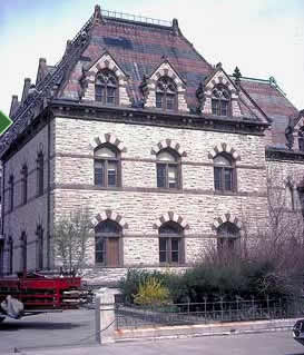 This is an image of a historic building with a highly visible roof, with stone dormers, decorative metalwork and patterned red and black slatework. Photo: NPS files.