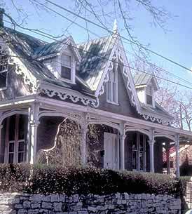 This is an image of a house with a gable roof, dormers and a wraparound porch, making it similar to many other houses of the period. But it is the wooden trim on the eaves and around the porch that gives this building its special visual character. Photo: NPS files.