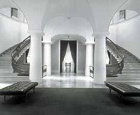 This is an image of an individually important space that is defined by its size, twin curving staircases, massive columns, and curving vaulted ceilings. Photo: National Portrait Gallery.