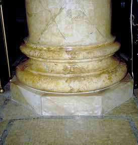 This is an image of an interior column featuring real marble at the base, imitation marble patterns on the plaster surface, and a tile floor surface that uses small mosaic tiles arranged to form geometric designs in several different colors. Photo: NPS files.