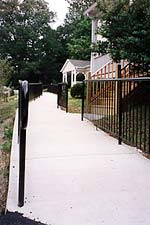 This is an image of an out-of-scale accessiblity ramp installed as part of a new office building. It dominates historic buildings on the block because of its length and materials. Photo: NPS files.