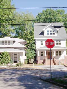 This is an image of a small historic house with a larger new house next to it. The new infill is proportionally out of scale and thus incompatible with this house and the other, smaller houses on the block. Photo: Dan Becker.
