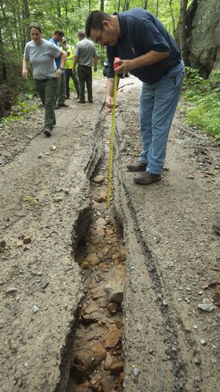 park staff surveying road damage