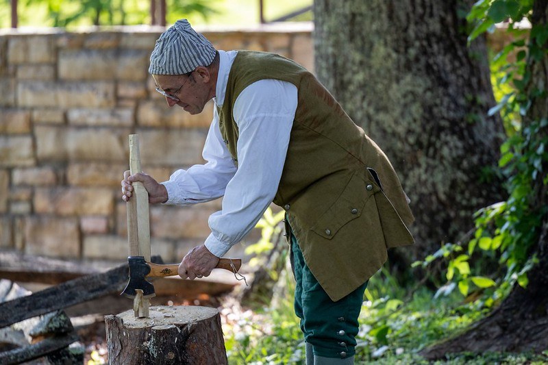 Woodworking demonstration Man in 1700s period clothing doing woodcarving
