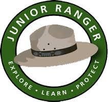 A green circle with white words Jr Ranger- Explore, Learn, Protect with an NPS flat hat