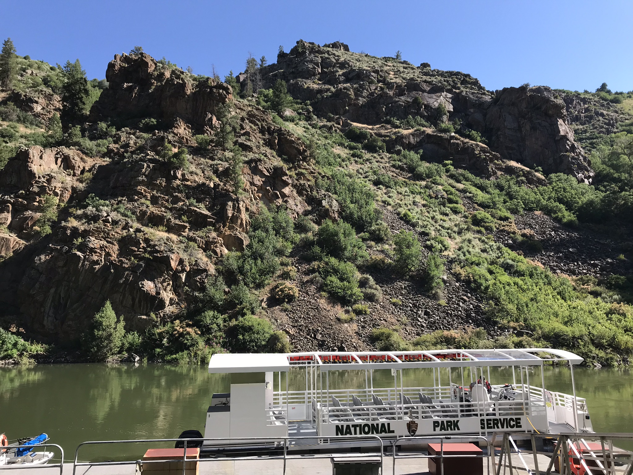 40 foot long pontoon boat sits at dock with cliffs in background