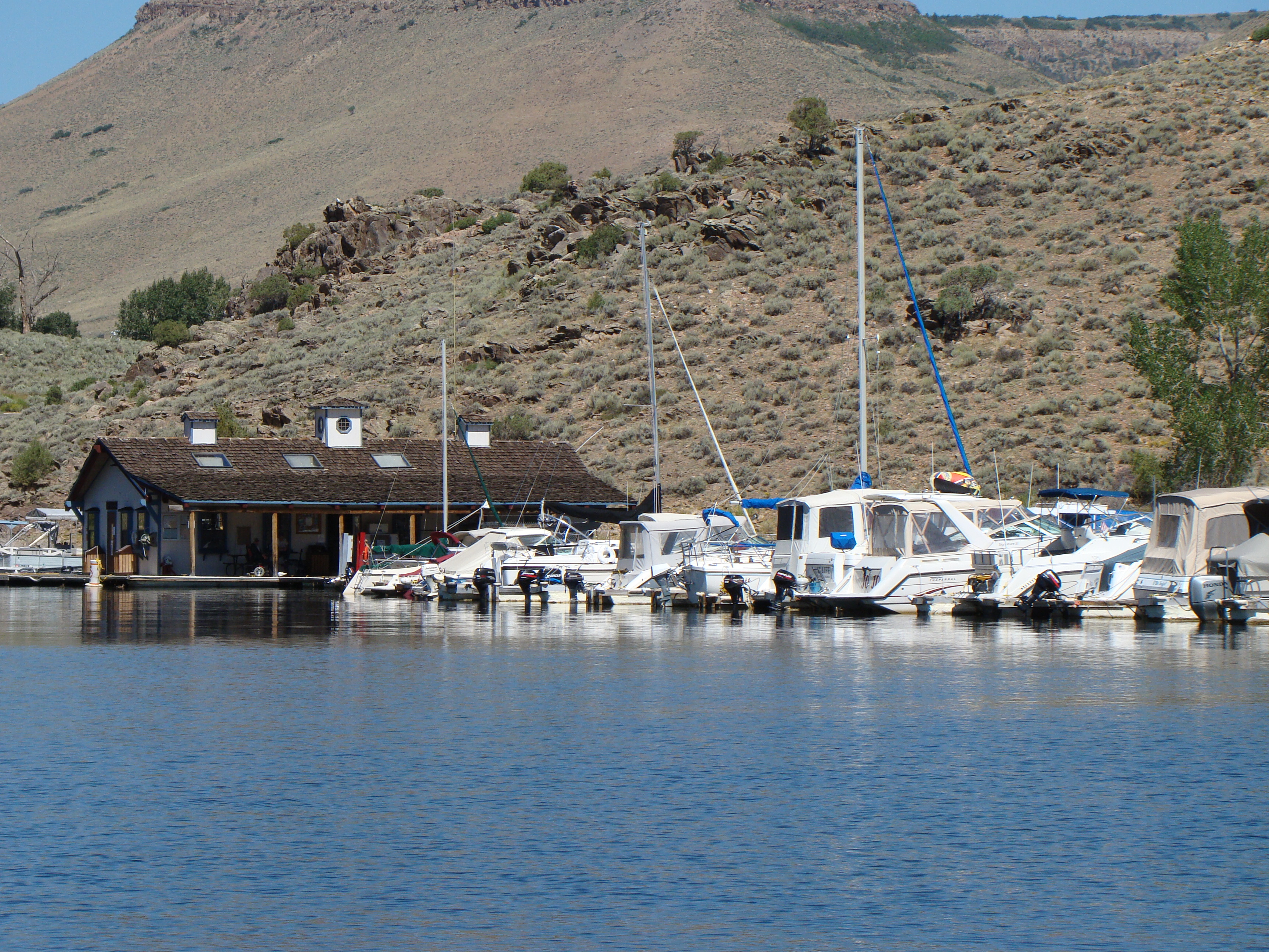 boats at Elk Creek Marina motor and sail boats at a marina on very blue lake with mountainside in background