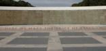 the words 'Here we mark the price of freedom' on a plaza in front of wall of stars