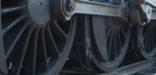 An engineer inspects the running gear of a steam locomotive at Steamtown NHS