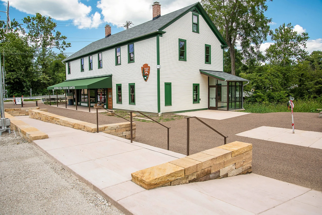 Boston Mill Visitor Center Two-story white building with green trim and a green awning that reads "Boston Mill Visitor Center."