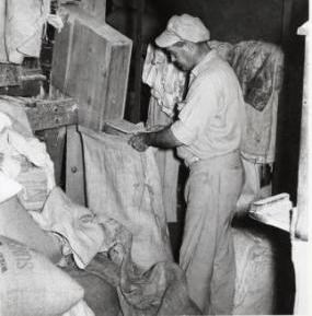 Black and white photo of Thomas G. Wilson working in mill, 1920s.