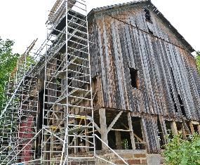 Modern photo of the historic Lindley Barn being restored. Scaffolding is stacked up along the side of the barn while the framing is being replaced. Modern photo of the historic Lindley Barn being restored. Scaffolding is stacked up along the side of the barn while the framing is being replaced.