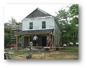 A house under construction, siding is missing revealing foam board insulation.