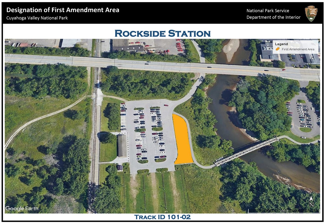 An aerial view of the Rockside Station area; in the middle of the photo is the Rockside Station parking lot; to the right of the lot - between it and the river - is an irregularly shaped yellow polygon indicating the location of the first amendment area.