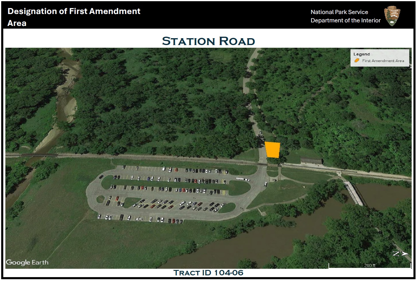Aerial view of the Station Road area; at center is the Station Road parking lot, its driveway entering from the west; west of the railroad tracks and north of the driveway a trapezoidal yellow polygon indicates the location of the first amendment area.