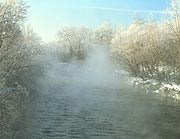 Frosted trees line the Cuyahoga River in winter, as fog rises from its surface. Frosted trees line the Cuyahoga River in winter, as fog rises from its surface.
