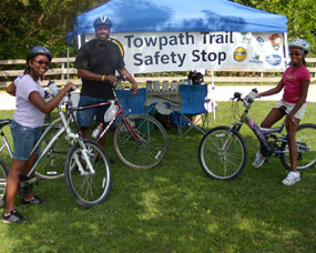 Three visitors on bikes at a Safe is Sound safety stop. Three visitors on bikes at a Safe is Sound safety stop.