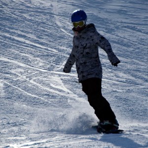 Snowboarder travels down Boston Mills ski slope.