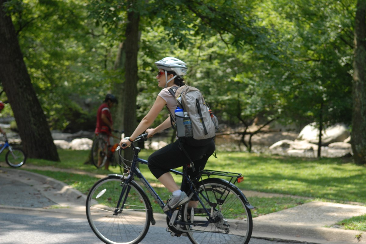 A visitor riding her bike through a National Park.
