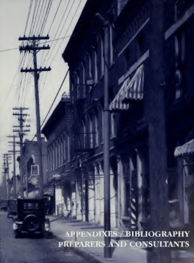 Large brick buildings along a street with telephone poles out front