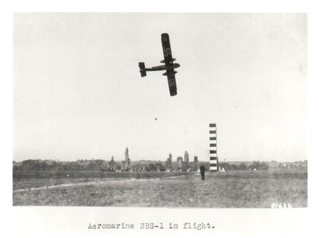 Aeromarine NBS1 flying past a pylon Black and white image of a Aeromarine NBS-1 flying past a pylon on the race course . In the background can be seen a mock-up of New York City, used as a bombing demonstration on the third day.