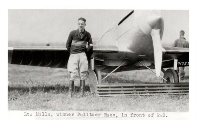 Pulitzer Winner Lieutenant H.H. Mills Black and white image of: Lieutenant H.H. Mills, winner of the Pulitzer Speed Trophy, posing in front of a Verville-Sperry racer.