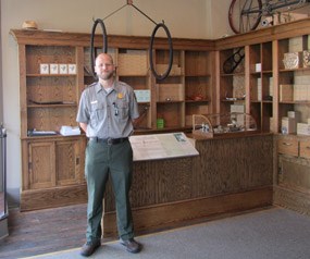 Ranger Langston in front of the counter inside of the Wright Cycle shop.
