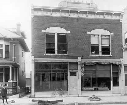 A large, two-story brick building with glass fronts on the lower floor.