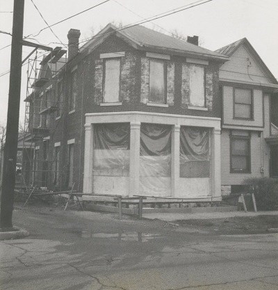 A brick building with covered-up windows and scaffolding around it.