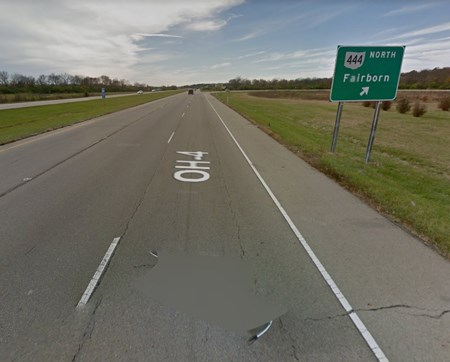 A green street sign next to the highway