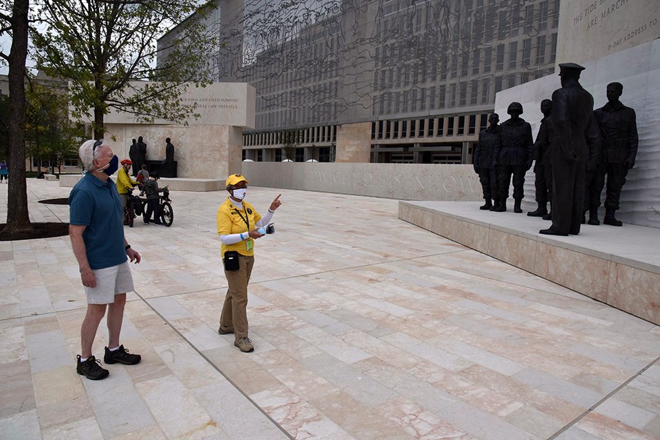 A volunteer speaks with a visitor at the Dwight D. Eisenhower Memorial