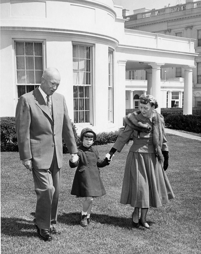 A couple holds hands with a young girl