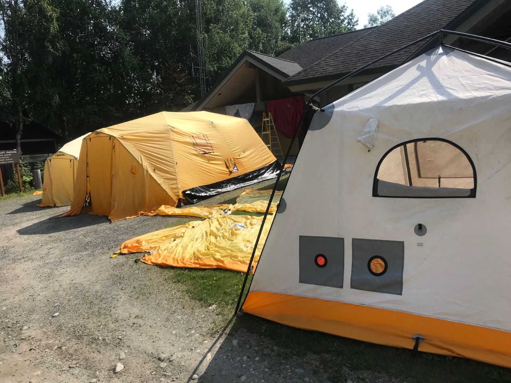 A row of big yellow tents sits outside a ranger station