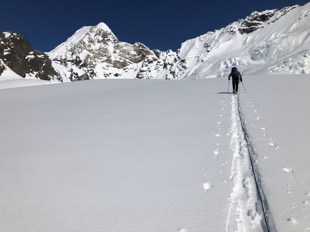 A climber skies to a distant peak