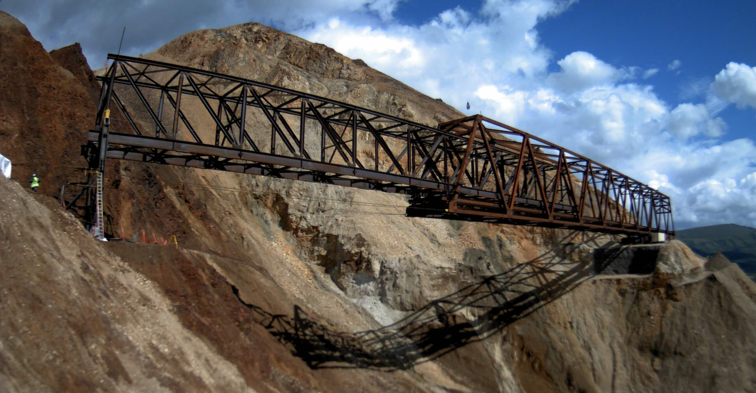 The launch truss extends all the way to the west side of the slide. The main bridge truss has begun to move left but is not yet connected to the west abutment.
