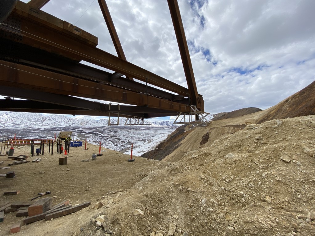 Large metal beams extend out over the east side of the slide to the west. Large metal beams extend out over the east side of the slide to the west.