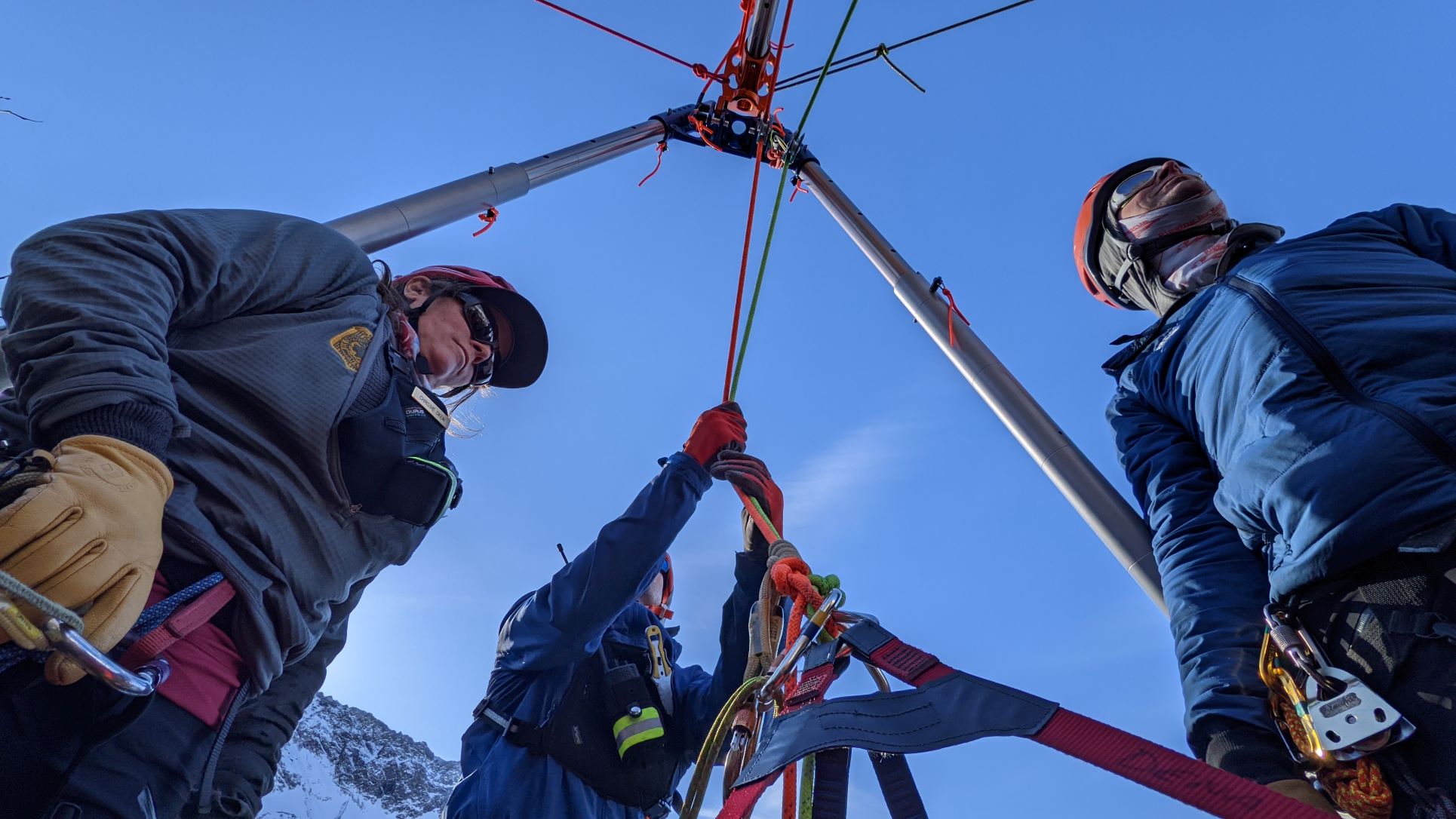 Three rangers rig up a rescue tripod during training