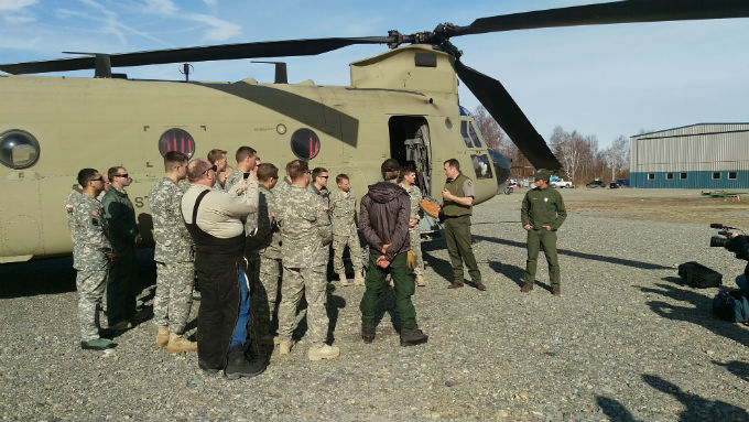 Rangers and military personnel standing outside a CH-47 helicopter. Rangers and military personnel standing outside a CH-47 helicopter.