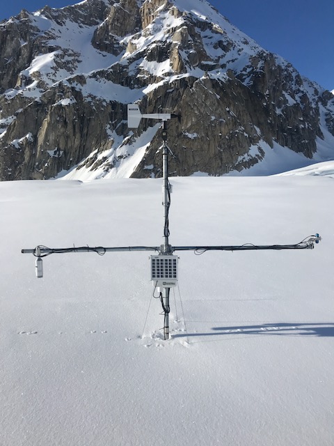 Basecamp weather-monitoring equipment partially buried in snow