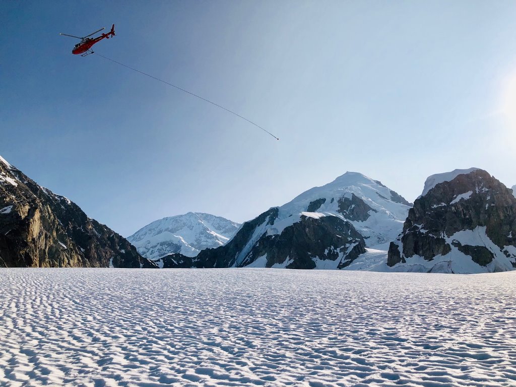 Headed back for more Helicopter with a long, empty rope trailing in the wind as it flies off