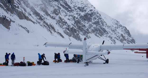 Climbers line up with their packs and duffels to board a small plane
