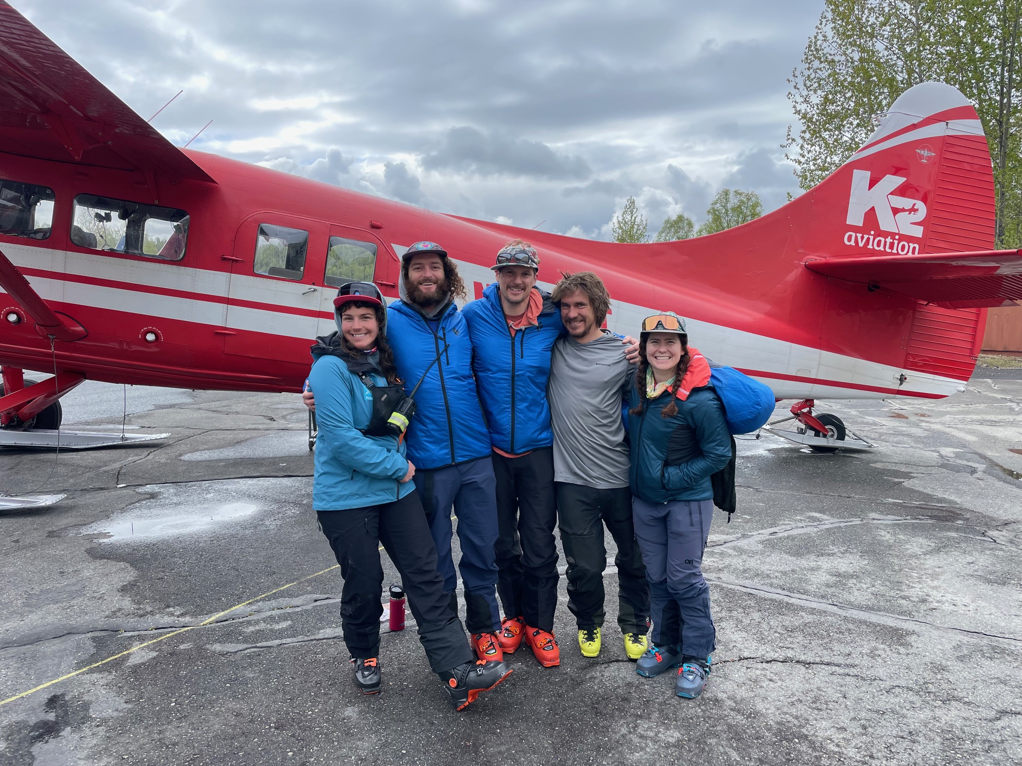 West Buttress Patrol #4 Five climbers huddle for a photo in front of a red and white airplane
