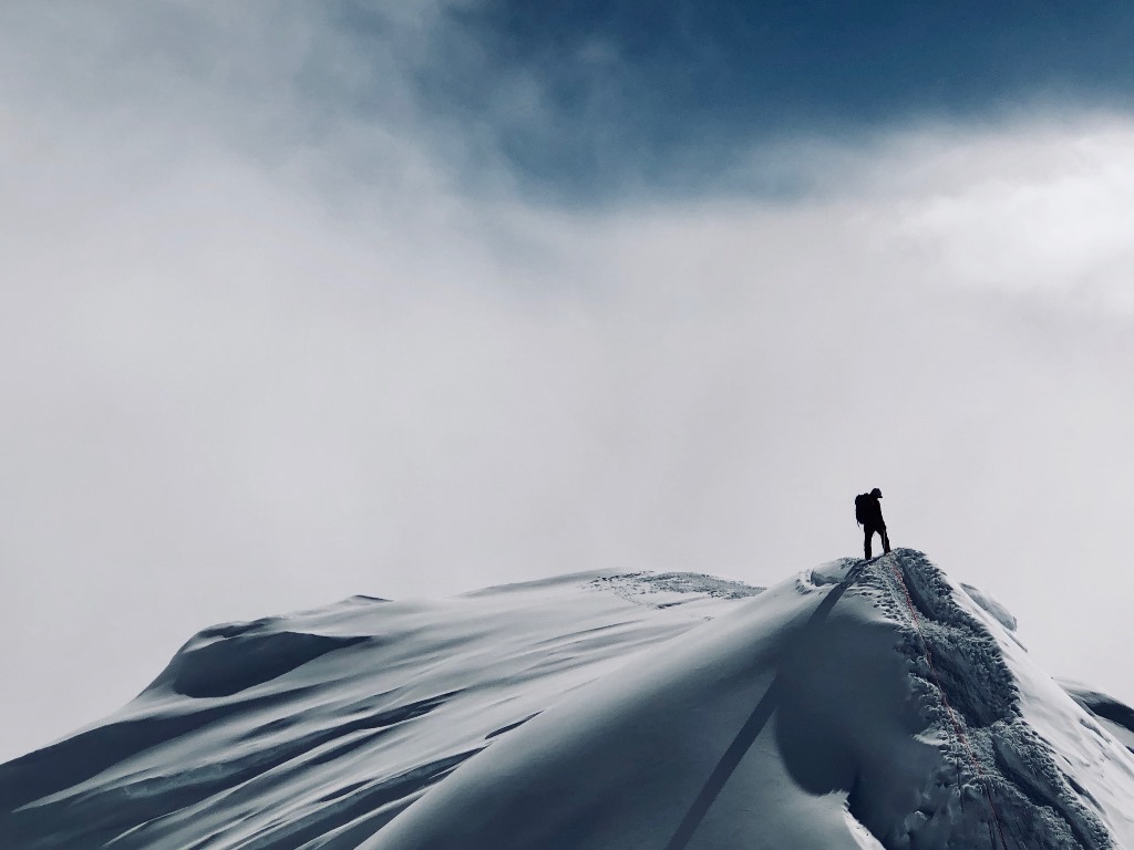 A lone ranger on the summit ridge Ranger stands on steep summit ridge looking off into the distance
