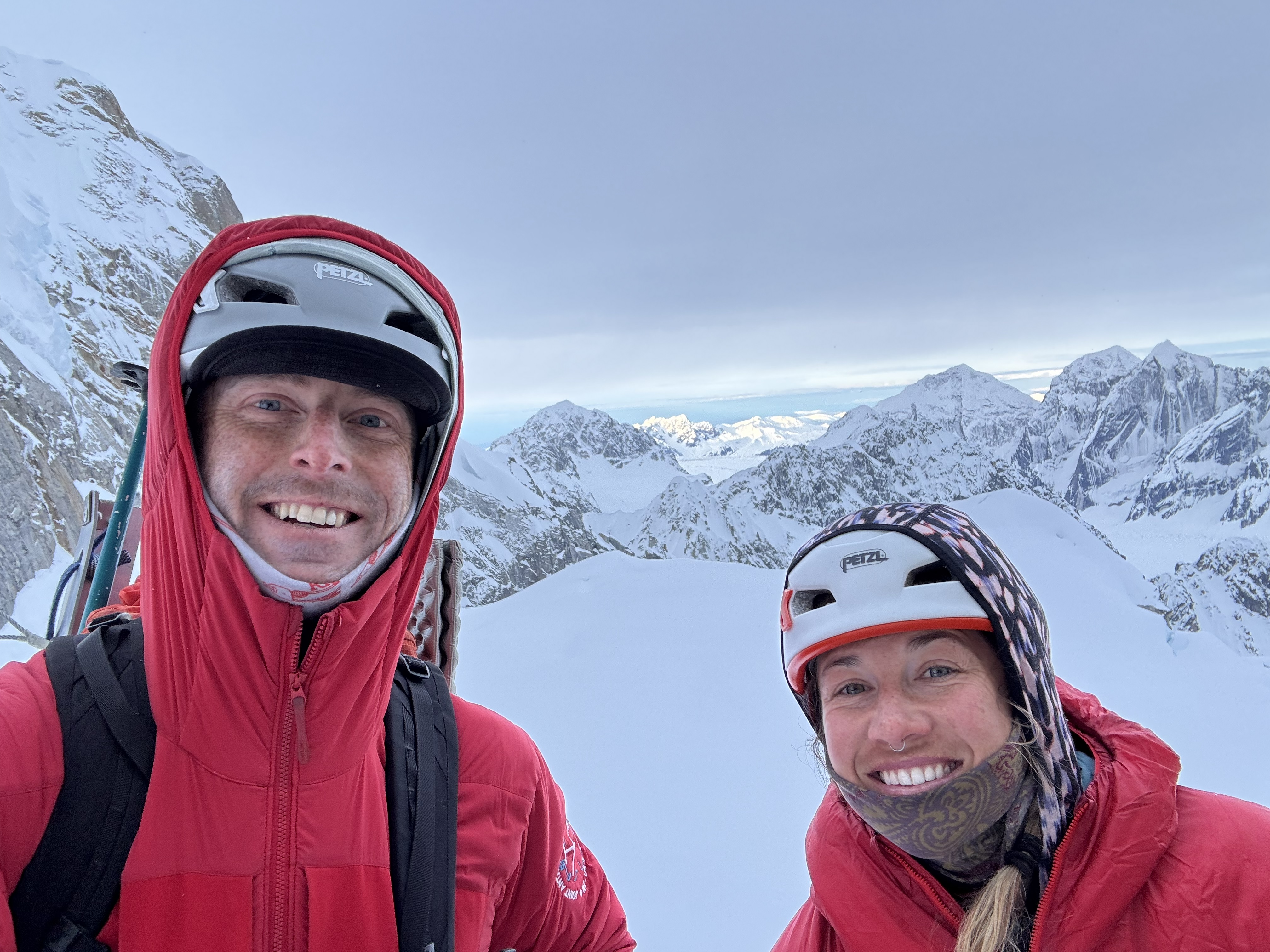 Happy climbing rangers Two smiling climbing rangers in red jackets with snowy peaks in the background