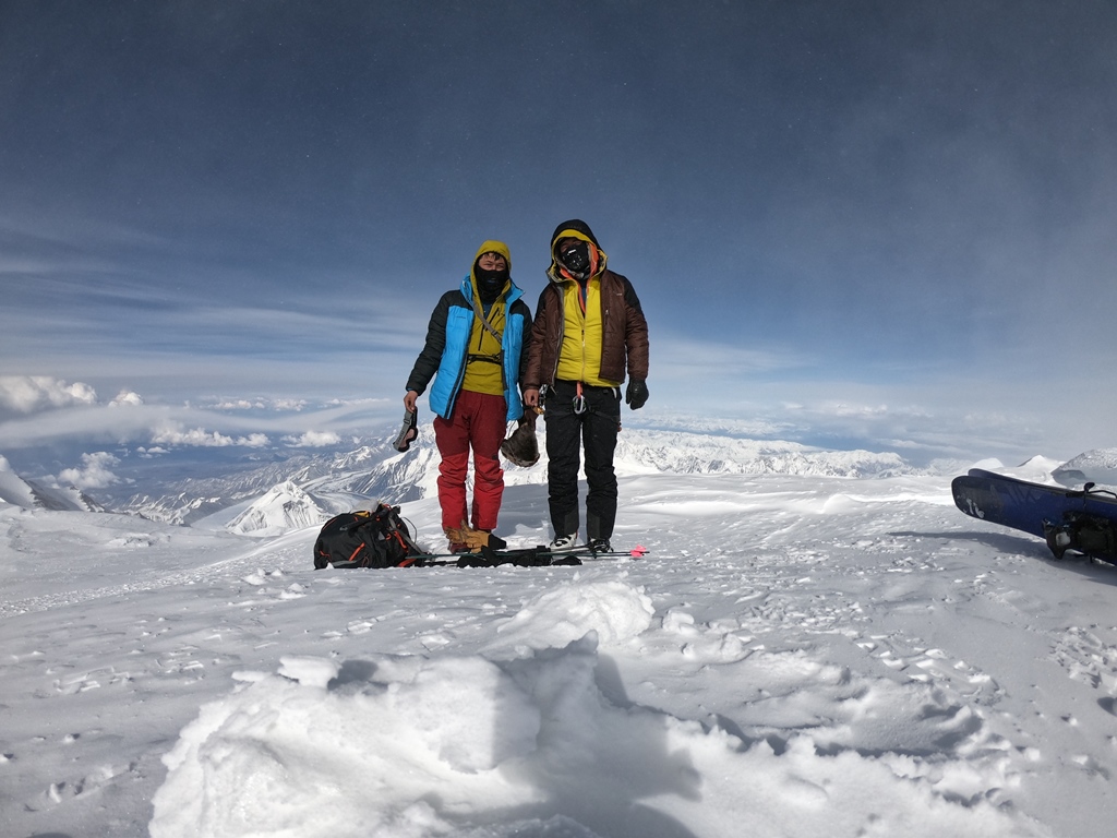 Two young mountaineers stand on top of the highest peak in North America