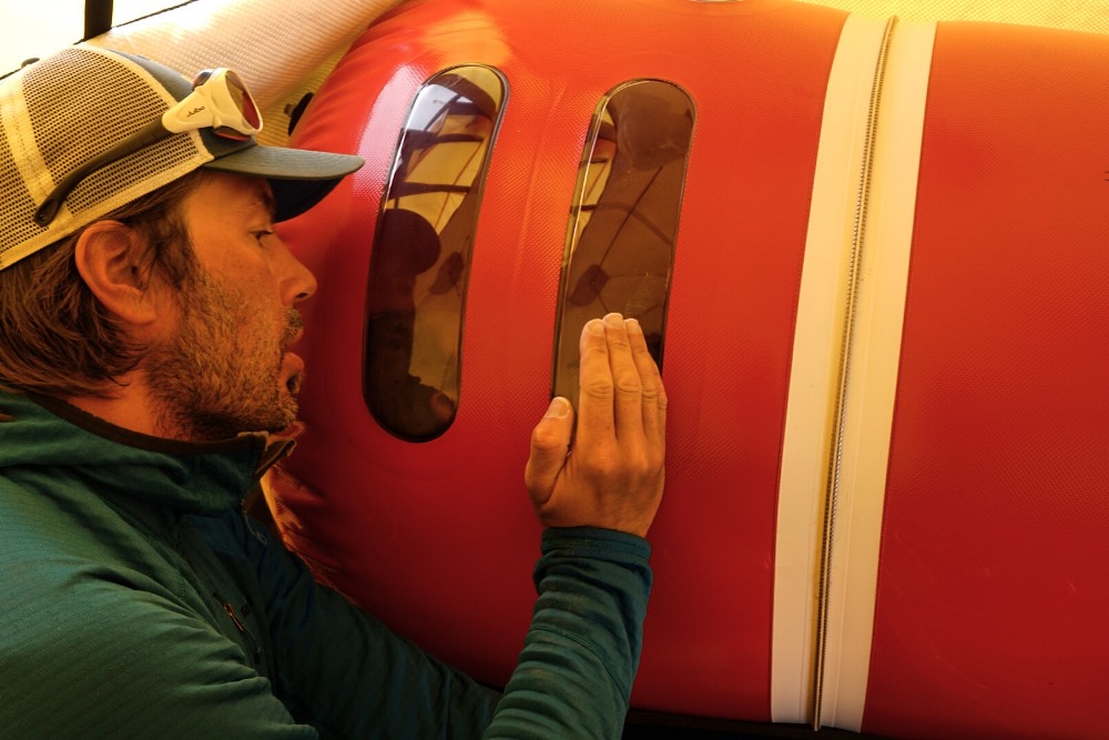 Medic peaks into the hyperbaric bag to check on a patient