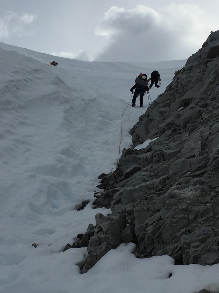 A mountaineer downclimbs Grizzly Gap